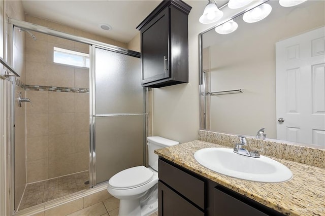 bathroom with tile patterned floors, vanity, toilet, and a shower with shower door