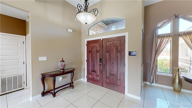 entryway featuring light tile patterned flooring and a high ceiling