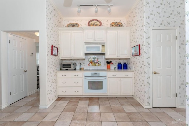 131 E Hibiscus St, South Padre Island, TX 78597 - kitchen with white appliances, wallpapered walls, a toaster, light countertops, and crown molding