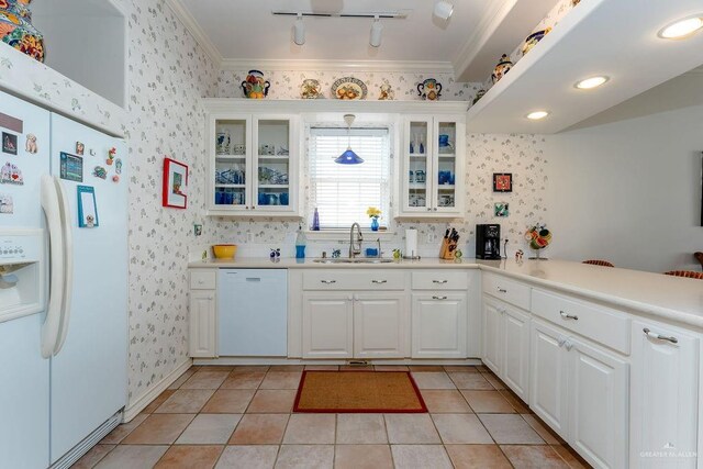 131 E Hibiscus St, South Padre Island, TX 78597 - kitchen with wallpapered walls, white appliances, glass insert cabinets, and a sink