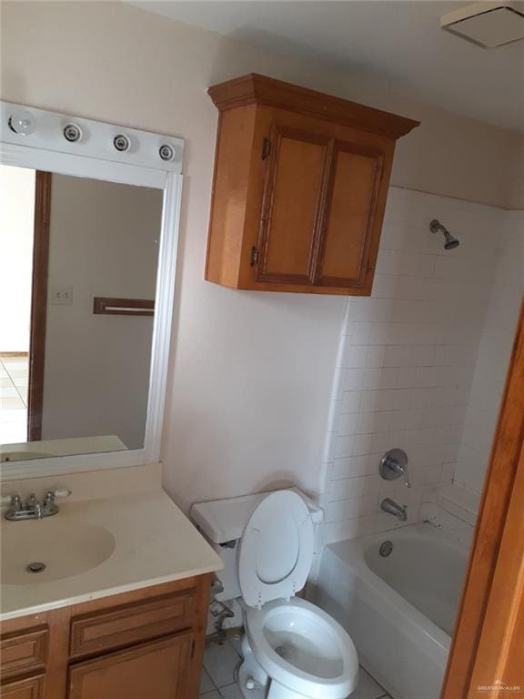 full bathroom with tile patterned floors, tiled shower / bath, vanity, and toilet