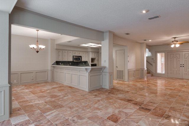 2114 Colorado St, Mission, TX 78572 - kitchen with stainless steel microwave, a decorative wall, a chandelier, a peninsula, and a textured ceiling