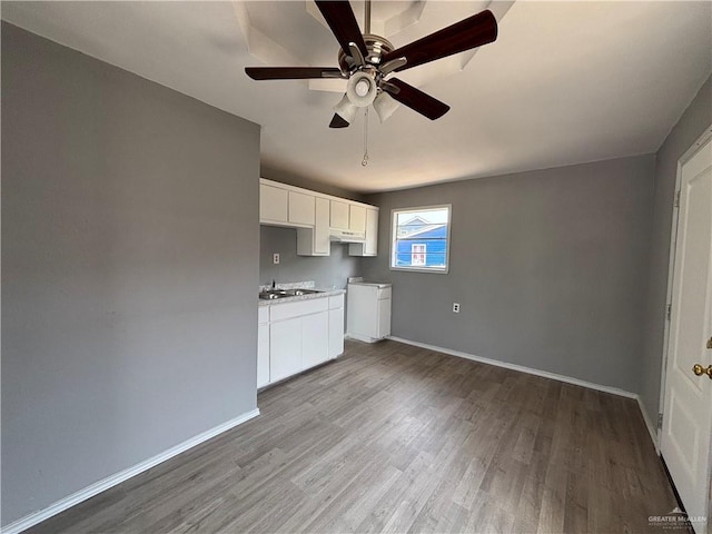 521 E Sherrye Ln, Pharr, TX 78577 - kitchen featuring wood finished floors, white cabinets, baseboards, ceiling fan, and a sink