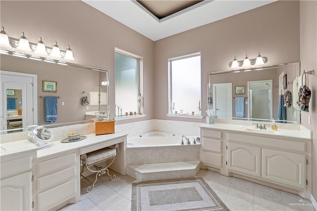 bathroom featuring tile patterned floors, tiled tub, and vanity