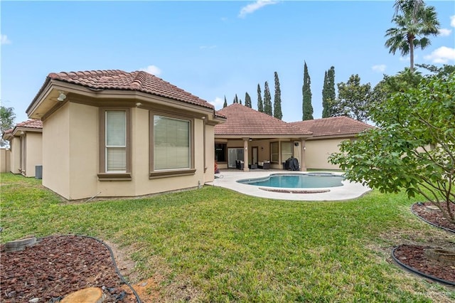 back of property featuring a lawn and a patio