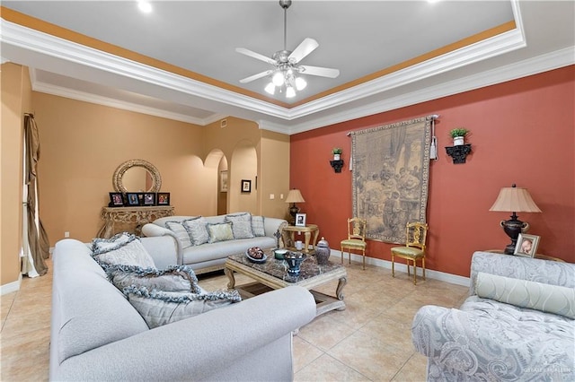 tiled living room featuring a tray ceiling, ceiling fan, and ornamental molding