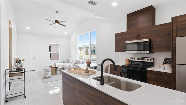 kitchen featuring appliances with stainless steel finishes, dark brown cabinetry, vaulted ceiling, ceiling fan, and sink