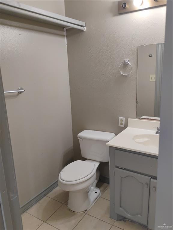 bathroom with tile patterned flooring, vanity, and toilet