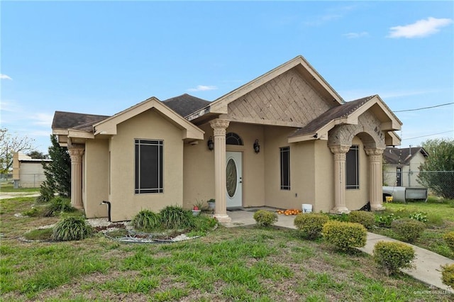single story home featuring fence, stucco siding, and roof with shingles