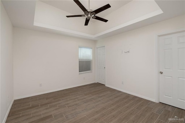 1615 W B St, Mission, TX 78572 - empty room featuring a raised ceiling, wood finished floors, ceiling fan, and baseboards