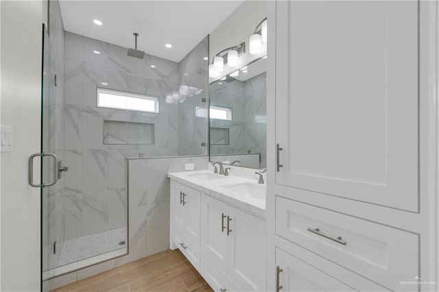 2205 Cardinal Dr, Weslaco, TX 78596 - bathroom with a marble finish shower, double vanity, wood finish floors, and recessed lighting