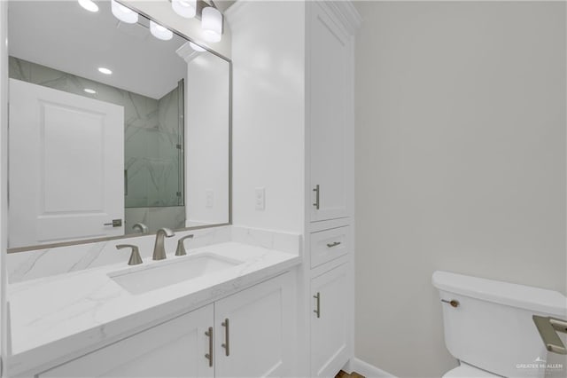 bathroom featuring vanity, toilet, and tiled shower