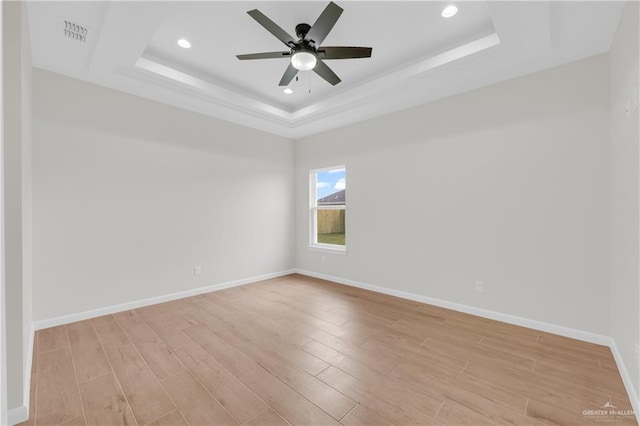 2205 Cardinal Dr, Weslaco, TX 78596 - unfurnished room featuring a tray ceiling, light wood-style floors, recessed lighting, and a ceiling fan