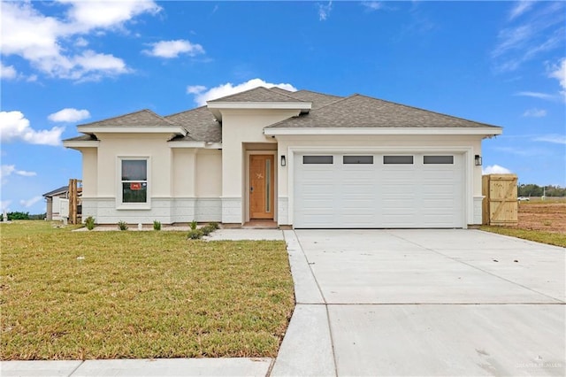 prairie-style home with a garage and a front lawn