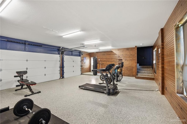 exercise room featuring wooden walls and water heater