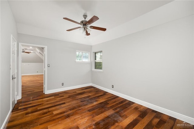 empty room with vaulted ceiling and dark wood-type flooring