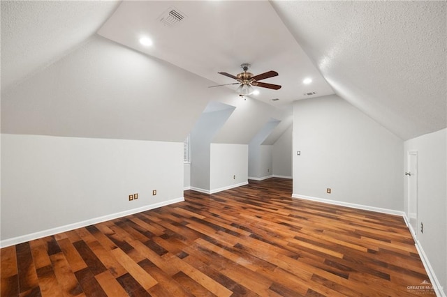 additional living space with a textured ceiling, ceiling fan, dark hardwood / wood-style flooring, and lofted ceiling