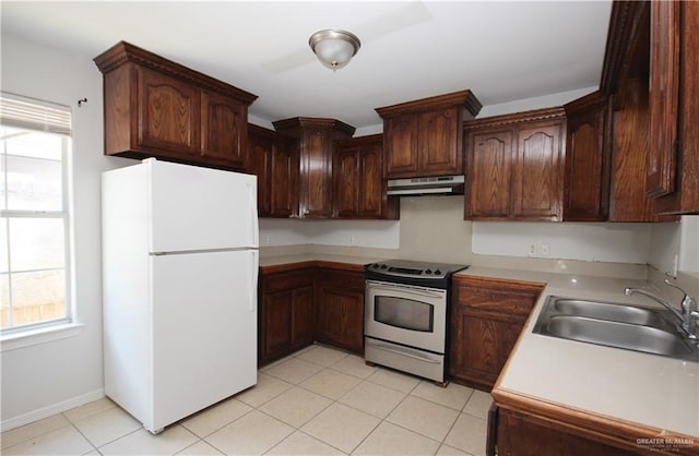 kitchen featuring sink, white refrigerator, a healthy amount of sunlight, and electric stove