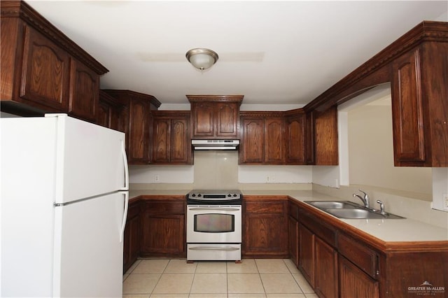 kitchen with dark brown cabinets, white appliances, sink, and light tile patterned floors