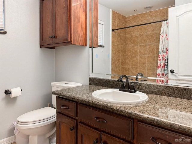 bathroom featuring curtained shower, vanity, and toilet