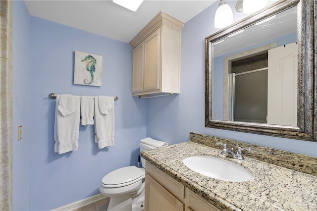 bathroom featuring vanity, a shower with door, and toilet