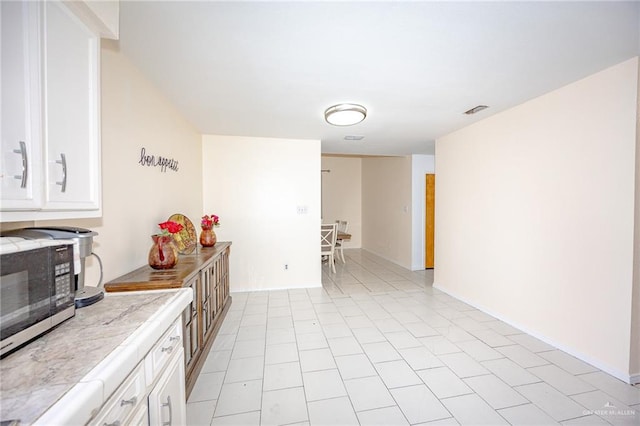 kitchen with white cabinets and light tile patterned floors