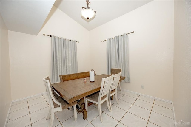 dining room featuring light tile patterned flooring and vaulted ceiling