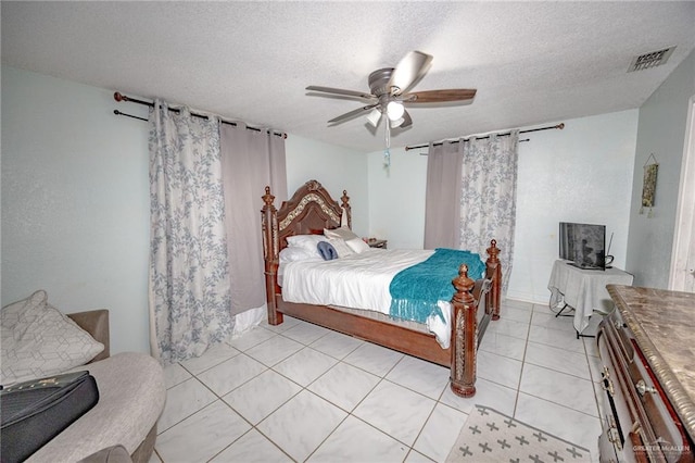 tiled bedroom with ceiling fan and a textured ceiling