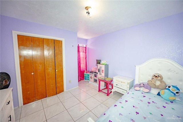 bedroom with light tile patterned floors and a closet