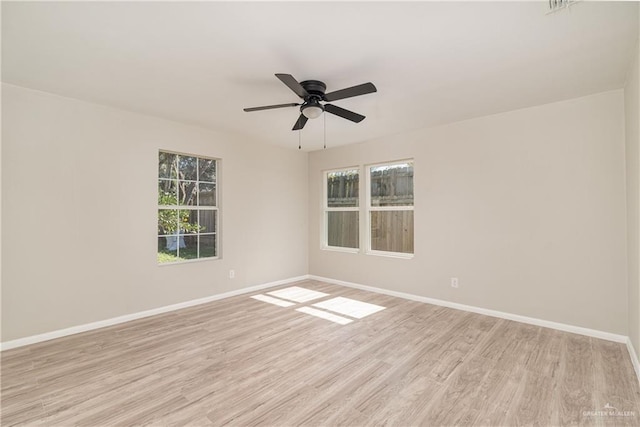 empty room with ceiling fan, a healthy amount of sunlight, and light hardwood / wood-style floors