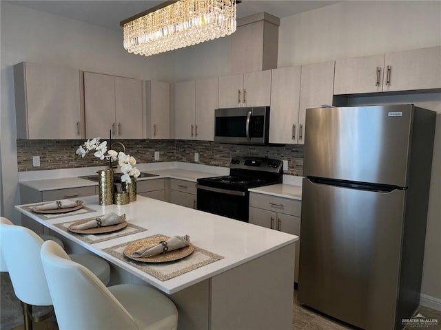 5302 Vision St, Rio Grande City, TX 78582 - kitchen featuring stainless steel appliances, light countertops, backsplash, and a kitchen breakfast bar
