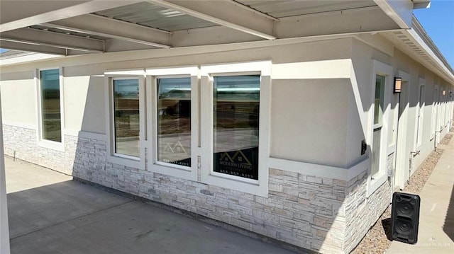 5302 Vision St, Rio Grande City, TX 78582 - view of side of property with stone siding, a patio, and stucco siding