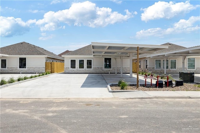5302 Vision St, Rio Grande City, TX 78582 - view of front of house featuring stone siding, stucco siding, fence, and driveway