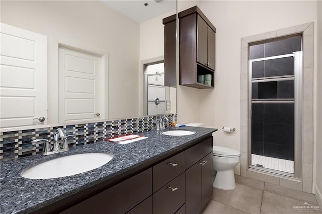 bathroom featuring toilet, walk in shower, tile patterned flooring, tasteful backsplash, and vanity