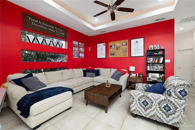 living room featuring ceiling fan, a raised ceiling, and tile patterned floors