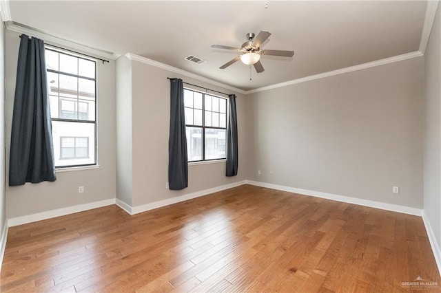 spare room with ceiling fan, ornamental molding, a healthy amount of sunlight, and hardwood / wood-style floors