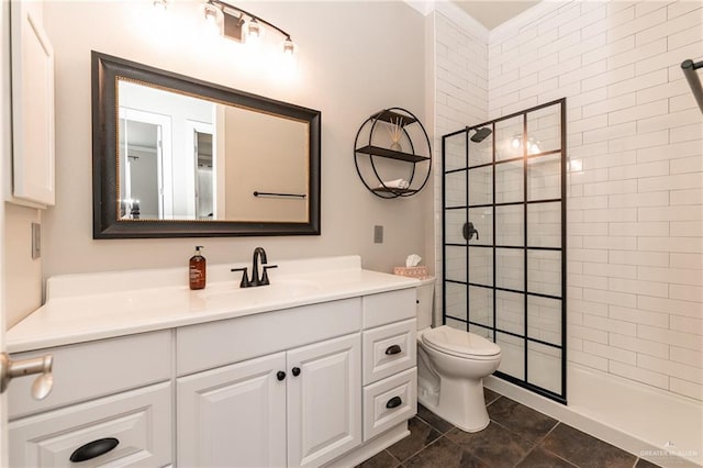 bathroom featuring vanity, toilet, tile patterned floors, and tiled shower