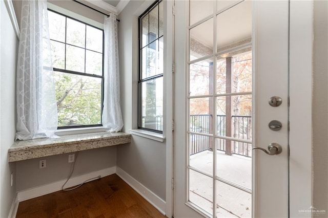 doorway to outside featuring dark hardwood / wood-style flooring and built in desk