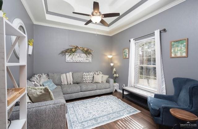 living room with crown molding, ceiling fan, dark hardwood / wood-style flooring, and a tray ceiling