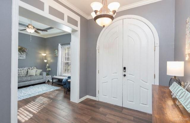 entrance foyer with dark hardwood / wood-style flooring, crown molding, and ceiling fan with notable chandelier