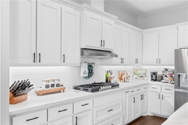 kitchen with backsplash, dark wood-type flooring, crown molding, white cabinetry, and stainless steel appliances