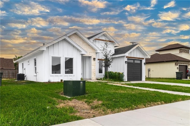 modern inspired farmhouse with board and batten siding, a front yard, driveway, and a garage