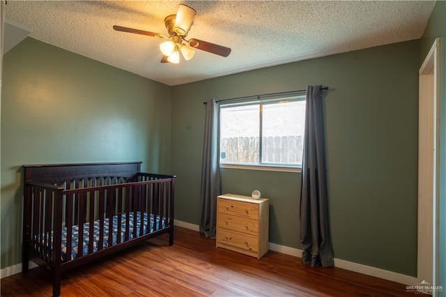 1306 Denver St, Edinburg, TX 78541 - bedroom featuring wood finished floors, a textured ceiling, ceiling fan, and a nursery area