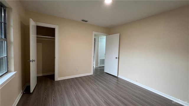 unfurnished bedroom with hardwood / wood-style floors and a closet