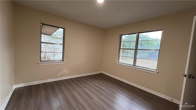 unfurnished room featuring dark hardwood / wood-style flooring and a wealth of natural light