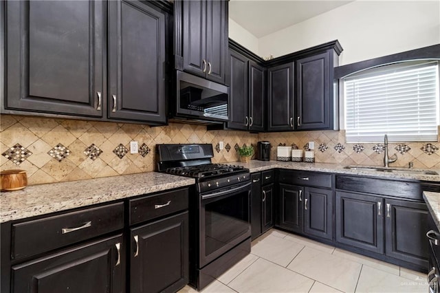 4805 Galilea St, Edinburg, TX 78542 - kitchen featuring stainless steel microwave, black gas stove, a sink, and tasteful backsplash