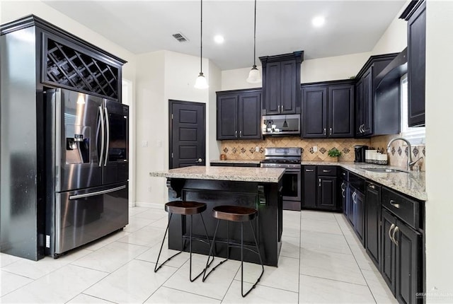 4805 Galilea St, Edinburg, TX 78542 - kitchen with stainless steel appliances, a sink, light stone countertops, tasteful backsplash, and dark cabinetry