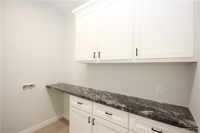 clothes washing area featuring washer hookup, cabinets, and light wood-type flooring