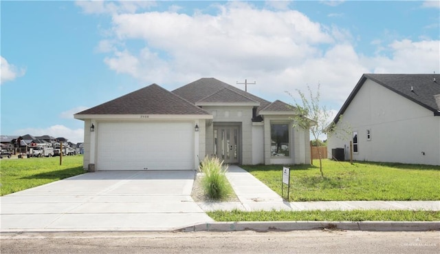 view of front facade featuring a front yard, central AC, and a garage