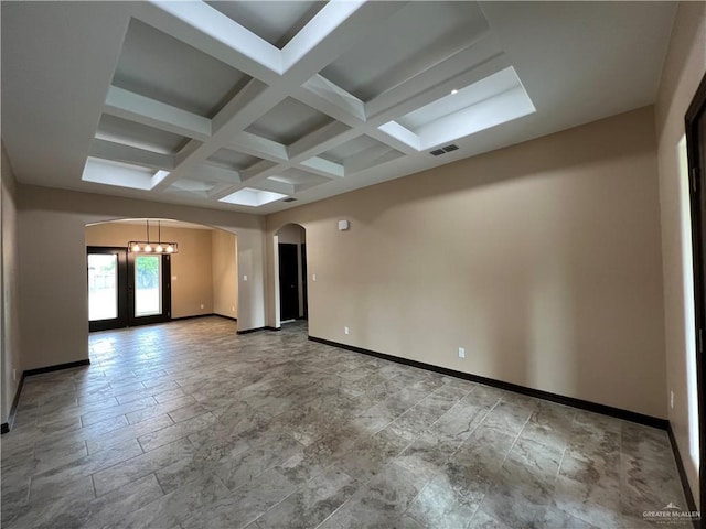 unfurnished room with arched walkways, baseboards, beamed ceiling, visible vents, and coffered ceiling